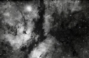 A nebula displays clouds and stars in deep space.